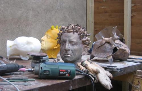 studio view of finishing bronzes; life cast and scanned rapid prototype models in background